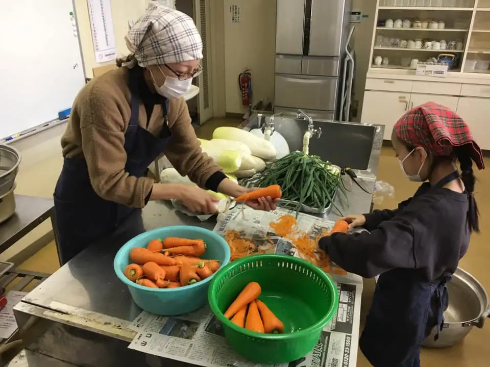 画像：調理を行うボランティアと児童